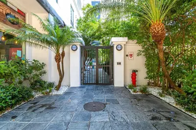 a door to a building with a courtyard with palm trees at Spectacular 2-Br Apartment 4 people 1107 in Miami