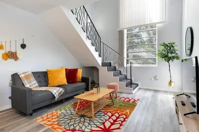 a living room with a couch and a staircase at Loft style 1b Apt , Fast Wi-Fi Virg14 in Miami