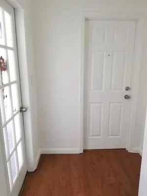an empty room with a white door and wooden floors at Royal Budget Inn in Miami