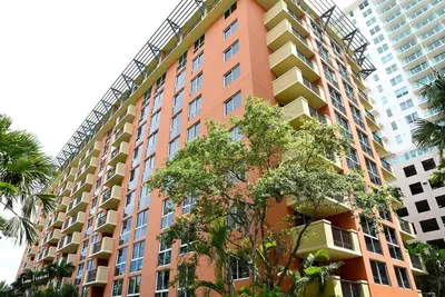 a tall orange building with trees in front of it at Ocean View 2bd2bth Hotel In Coconut Grove in Miami