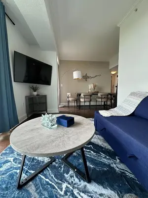 a living room with a blue couch and a table at Ocean View 2bd2bth Hotel In Coconut Grove in Miami