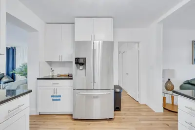 a refrigerator in a kitchen with white cabinets at Tranquil Pool Home in Hollywood Close to Beach Airport in Hollywood
