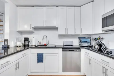 a white kitchen with white cabinets and appliances at Tranquil Pool Home in Hollywood Close to Beach Airport in Hollywood