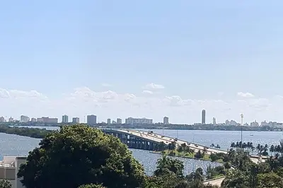 a bridge over a river with a city in the background at Miami design district, view of the bay - city in Miami