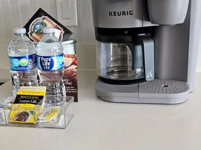 a coffee maker and bottles of water on a counter at Miami design district, view of the bay - city in Miami