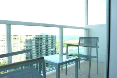 a glass table and a chair on a balcony at Amazing Studio - Walking Distance To Cocowalk in Miami