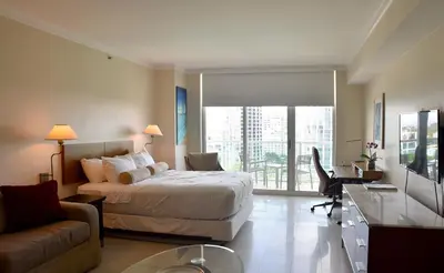 a bedroom with a bed and a desk and a couch at Amazing Studio - Walking Distance To Cocowalk in Miami