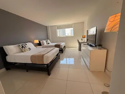 a bedroom with two beds and a flat screen tv at SPECIAL Beautiful Modern Beach Condo in Miami Beach