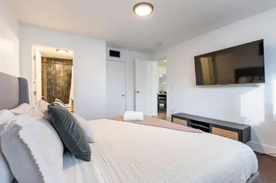 a bedroom with a bed with a television on the wall at Cozy Miami Home Pet-friendly & with Free Parking in Miami