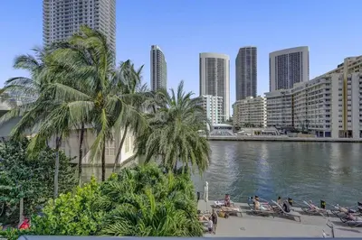 people sitting on chairs next to a river in a city at Upscale Resort 4 Bedrooms 3 Bath in Hallandale Beach