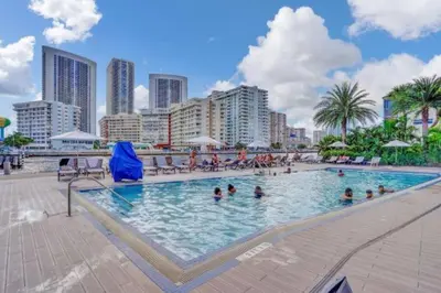 a large swimming pool with people in a city at Upscale Resort 4 Bedrooms 3 Bath in Hallandale Beach