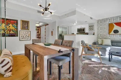 a kitchen and living room with a table and chairs at Treetop Retreat! Cozy 2 Bedroom In Heart Of Grove in Miami