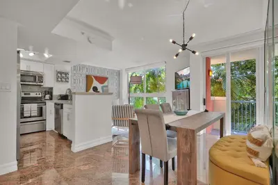 a kitchen and dining room with a table and chairs at Treetop Retreat! Cozy 2 Bedroom In Heart Of Grove in Miami