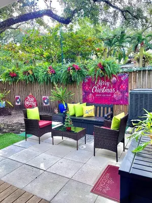 a patio with a couch and chairs and a fence at The Boutique Guest House in Miami