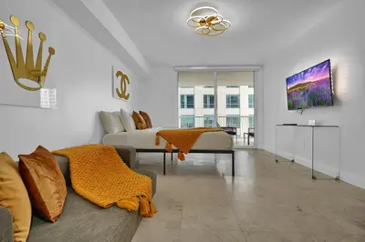a living room with a couch and a tv at Zeus' Sanctuary Ocean View In Brickell Miami in Miami