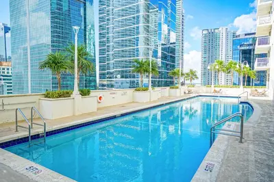 a swimming pool on the roof of a building with tall buildings at Zeus' Sanctuary Ocean View In Brickell Miami in Miami