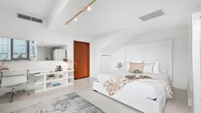 a white bedroom with a bed and a desk at Oceanview Private Townhouse at The Setai 1505-THB in Miami Beach