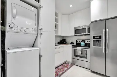 a kitchen with white cabinets and stainless steel appliances at SOBE MONARCH 2 - 2 Bedroom 2 Bathroom Apts - 2 Independent 1 bedrooms apts in Miami Beach