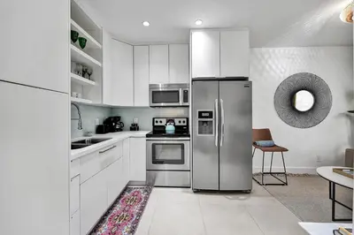 a kitchen with white cabinets and a stainless steel refrigerator at SOBE MONARCH 2 - 2 Bedroom 2 Bathroom Apts - 2 Independent 1 bedrooms apts in Miami Beach