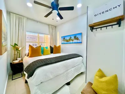 a bedroom with a bed with yellow pillows and a ceiling fan at SOBE MONARCH 2 - 2 Bedroom 2 Bathroom Apts - 2 Independent 1 bedrooms apts in Miami Beach