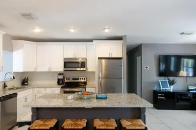 a kitchen with white cabinets and a granite counter top at Miami Beach Villa with Sparkling Pool! Sleeps 10+! in North Miami Beach