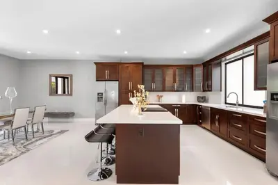 a large kitchen with wooden cabinets and a large island at Granada Modern Luxury in Massive Mansion with Heated Pool in Miami
