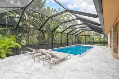 a swimming pool in a glass house with a swimming poolvisor at VillaKoBo Heated Pool Spa Bar Tennis Golf in Miami