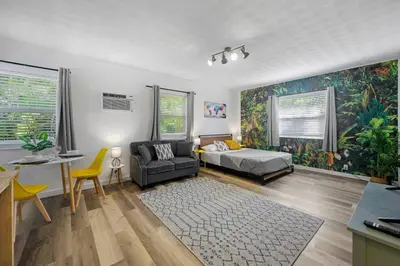 a bedroom with a bed and a couch and a table at New stylish open space: fast Wii-fi and parking in Fort Lauderdale