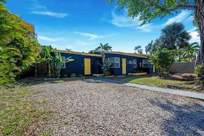 a blue and yellow house with a gravel driveway at New stylish open space: fast Wii-fi and parking in Fort Lauderdale