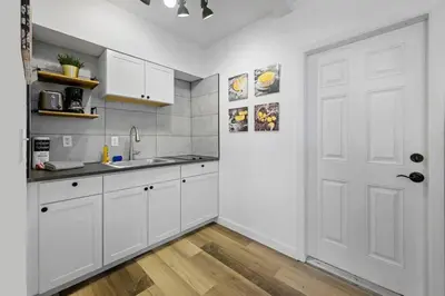 a kitchen with white cabinets and a white door at New stylish open space: fast Wii-fi and parking in Fort Lauderdale