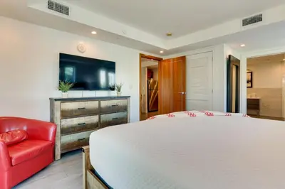 a bedroom with a white bed and a red chair at Miami Beach Vacation Rental with Rooftop Pool Access in Miami Beach