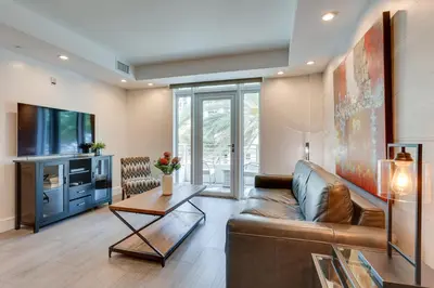 a living room with a couch and a tv at Miami Beach Vacation Rental with Rooftop Pool Access in Miami Beach