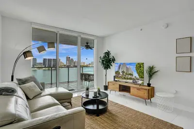 a living room with a couch and a large window at Marina Bay Sunny Isles 1005 in Miami Beach