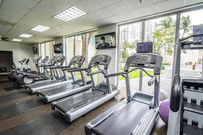 a gym with rows of treadmills at Spacious apartment of 2BR - 2BTH near of the beach great price in Miami Beach