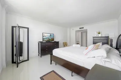 a white bedroom with a large bed and a television at Spacious apartment of 2BR - 2BTH near of the beach great price in Miami Beach