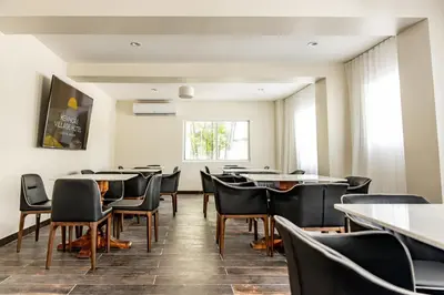 a dining room with tables and chairs and a window at Kenmore Village Hotel, South Beach in Miami Beach