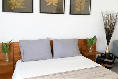 a bed with two pillows and some pictures on the wall at Newely remodeled apartment only 1 min to the beach! in Miami Beach