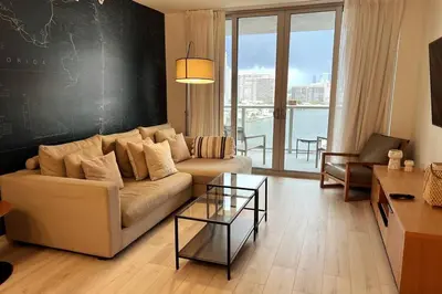 a living room with a couch and a glass table at Ocean Breeze & City Style, Miami Beach Luxury Stay -A in Hallandale Beach