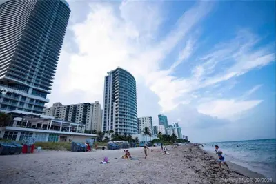 a group of people on a beach with buildings at Ocean Breeze & City Style, Miami Beach Luxury Stay -A in Hallandale Beach