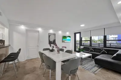a living room with a white table and chairs at Modern Miami Beach Condo with Beach Service & Pool in Miami Beach