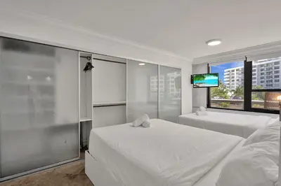 a bedroom with two beds and a flat screen tv at Modern Miami Beach Condo with Beach Service & Pool in Miami Beach