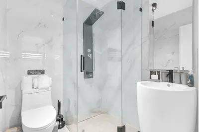 a bathroom with a shower and a toilet and a sink at Heated Pool Modern 5 Bedrooms House 10 minutes to the Ocean in Miami