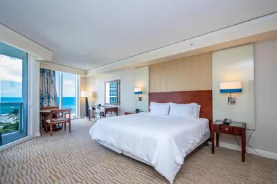 a hotel room with a bed and a large window at TRUMP INTERNATIONAL BEACH RESORT 2 BEDROOM APARTMENT 1600 Sqf Ocean and Bay View in Miami Beach