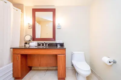 a bathroom with a sink and a toilet and a mirror at TRUMP INTERNATIONAL BEACH RESORT 2 BEDROOM APARTMENT 1600 Sqf Ocean and Bay View in Miami Beach