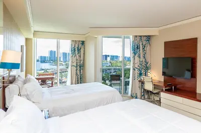 a hotel room with two beds and a flat screen tv at TRUMP INTERNATIONAL BEACH RESORT 2 BEDROOM APARTMENT 1600 Sqf Ocean and Bay View in Miami Beach