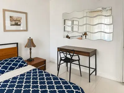 a bedroom with a desk and a bed and a desk with a chair at 2 BEDROOM ON THE BEACH ! in Miami Beach
