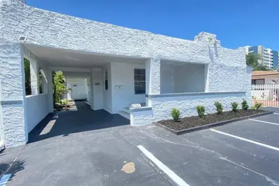a white building with a parking lot at Heart of Miami sleeps 10 near Little Havana Beaches in Miami