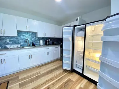 a kitchen with white cabinets and an open refrigerator at Lively Home near Downtown, stadium, Wynwood in Miami