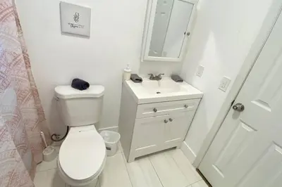 a white bathroom with a toilet and a sink at Lively Home near Downtown, stadium, Wynwood in Miami