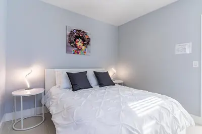 a white bedroom with a large white bed with pillows at Villa Aura Heated Pool 4 Bedrooms 5 minutes to the Ocean in Fort Lauderdale